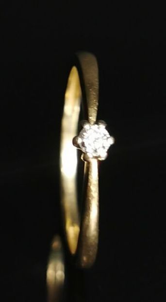 null Bague solitaire en or jaune ornée d'un diamant pesant environ 0.05 carat.

Tour...