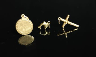 null Trois pendentifs en or jaune figurant un dauphin, un crucifix, l'autre circulaire...