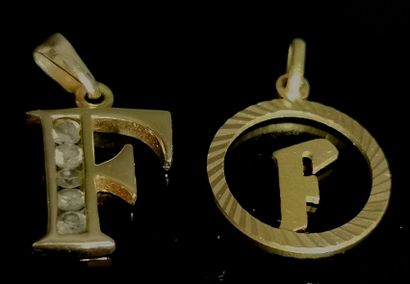 null Deux pendentifs en or "F", l'un orné de pierres blanches.

Poids brut : 2,83...