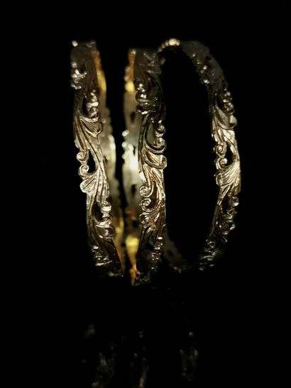 null Trois bracelets rigides en or jaune ciselé à décor d'enroulements.

D_7cm. 

60,77...