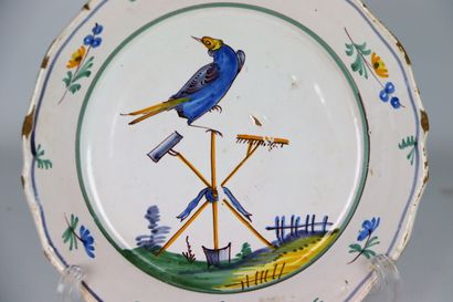 null NEVERS.
Earthenware plate with polychrome decoration of a bird perched on tools...