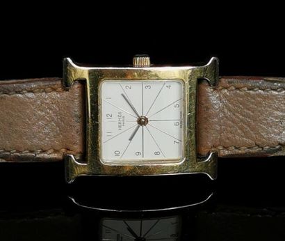 null HERMES.
Montre bracelet de dame en métal doré, le boitier formant la lettre...