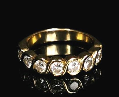 null Bague en or jaune ornée de sept diamants ronds en serti-clos pesant chacun environ...