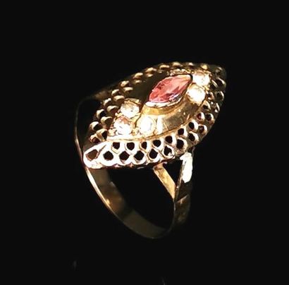 null Bague navette en or jaune à décor ajouré et ornée de pierres blanches et rouges.
Tour...