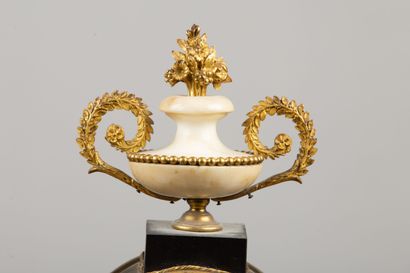 null Portico clock in marble and gilt bronze, topped by a vase with handle.
The dial...