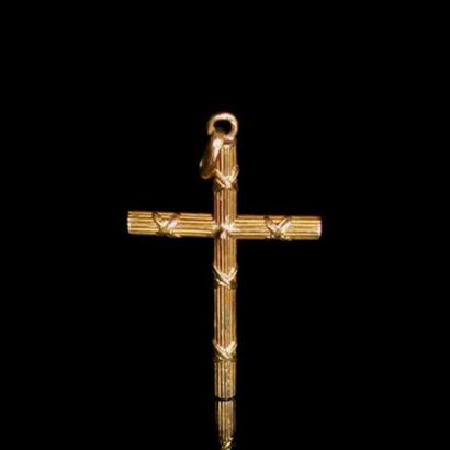 null Croix en or jaune à décor strié et de rubans.
0.99 gramme, 18K, 750°/00