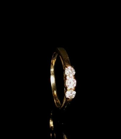null Bague en or jaune ornée de trois diamants taille ronde pesant 0.05 carat chacun...