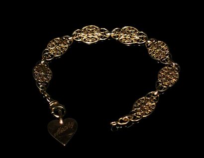 null Bracelet en or jaune à décor filigrané et orné d'un pendeloque figurant un coeur,...