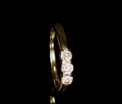null Bague en or jaune ornée de trois diamants taille ronde pesant 0.05 carat chacun...