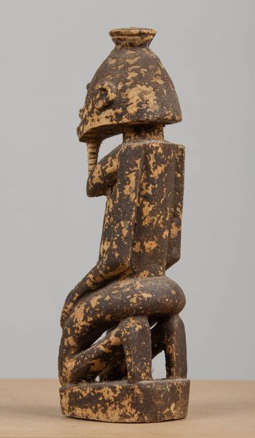 null MALI.
Sculpture Dogon en bois partiellement patiné figurant une femme à genoux,...