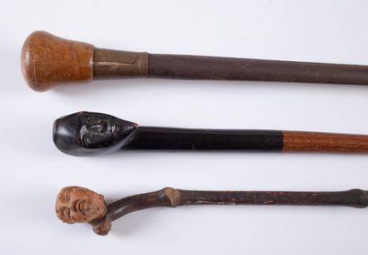 null Three canes, two in wood with head-carved knob and one in iron with wooden knob.
L_...