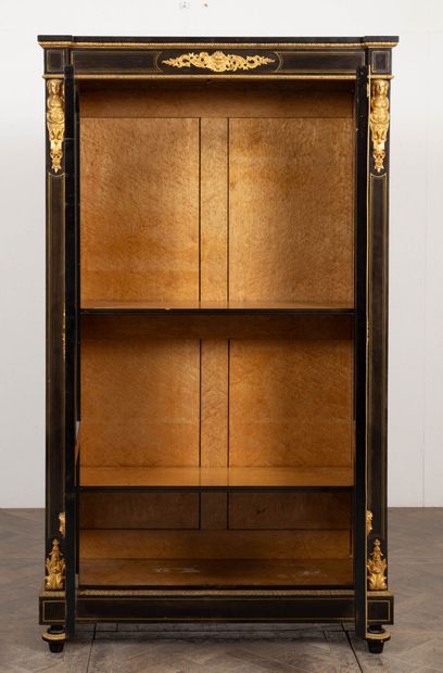 null Large blackened wood and gilded bronze bookcase. 
It opens on two doors with...