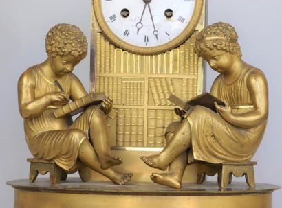 null Pendule à la bibliothèque en bronze doré, figurant deux enfants lisant près...