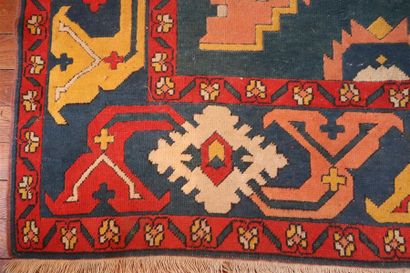 null Important tapis en laine polychrome à décor de motifs stylisés sur champ bleu,...