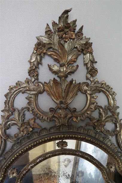 null Important miroir à parecloses en bois sculpté argenté à décor rocaille ajouré...