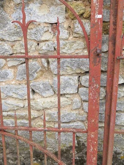 null Portail ancien en fer forgé relaqué rouge à décor de flèches, arcatures et enroulements...