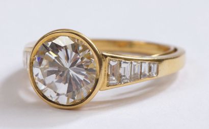 null RING decorated with a BRILLANT set in yellow gold between two lines of five...