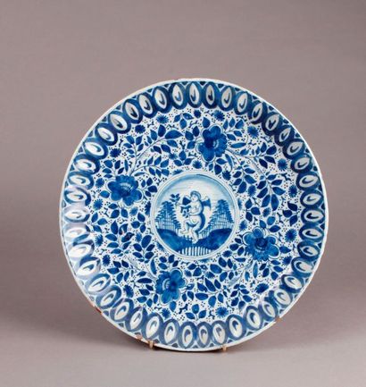 DELFT Round earthenware dish with blue monochrome decoration of a love in the center...