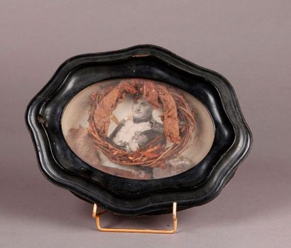 null HISTORICAL MEMORY. An oval frame of moving form made of blackened wood with...