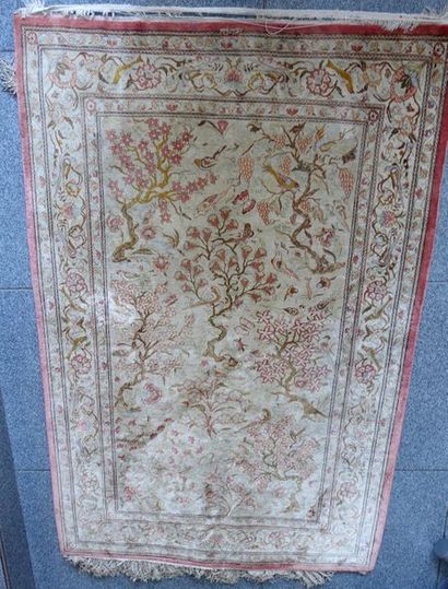 null Wool and silk Persian carpet with a decoration of branches with birds.

(Wear,...