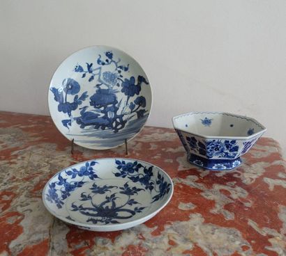 null Two porcelain plates and an octagonal bowl decorated with scrolls in blue monochrome....