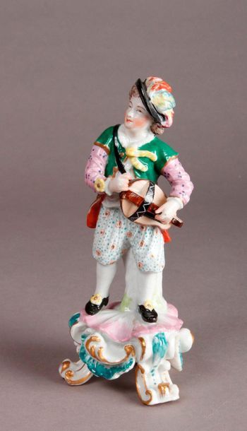 Angleterre Porcelain statuette representing a man playing the hurdy-gurdy standing...