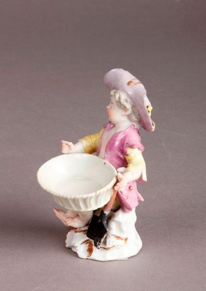 MEISSEN Porcelain statuette representing a young boy sitting, holding a basket on...