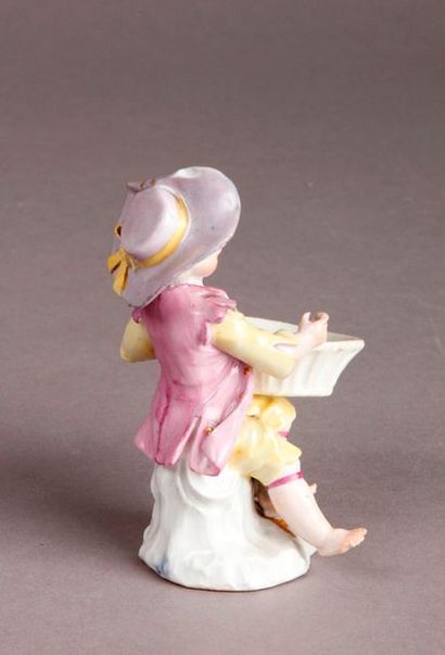 MEISSEN Statuette en porcelaine représentant un jeune garçon assis, tenant un panier...