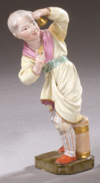 HÖCHST Porcelain statuette representing a young Chinese man standing, wiggling, holding...
