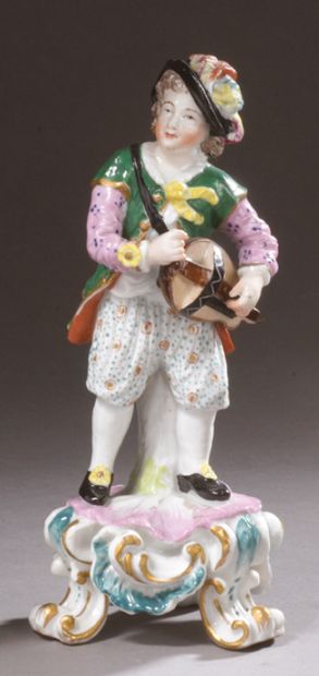Angleterre Porcelain statuette representing a man playing the hurdy-gurdy standing...