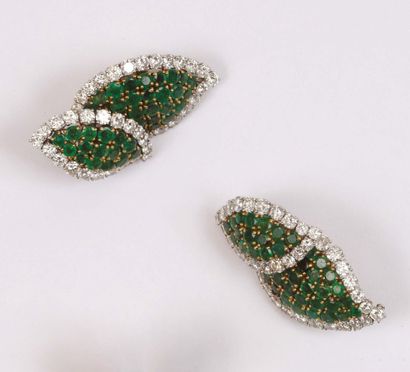  PAIR OF EAR CLIPS representing two leaves paved with round emeralds and bordered...