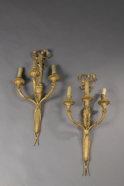 null A Pair of ormolu quivers sconces with three arms of light decorated with foliage...