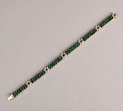 null BRACELET made of two lines of round emeralds cut with six flower motifs, one...