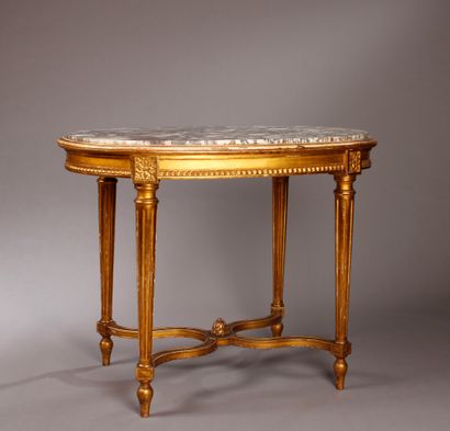 Table ovale en bois doré à décor de rais...