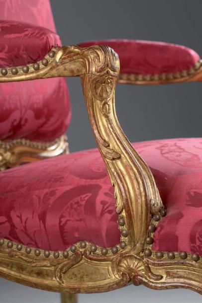 null Paire de larges fauteuils à dossier plat finement sculptés et dorés à décor...