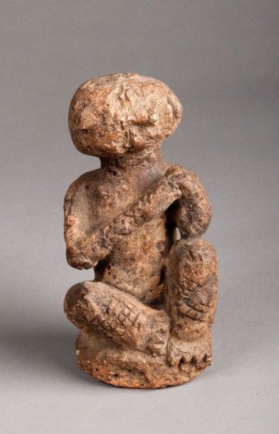 AFRIQUE Fétiche funéraire représentant un personnage assis en tailleur en pierre...