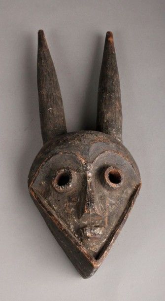 AFRIQUE Masque animalier à cornes en bois sombre. H. 38 cm