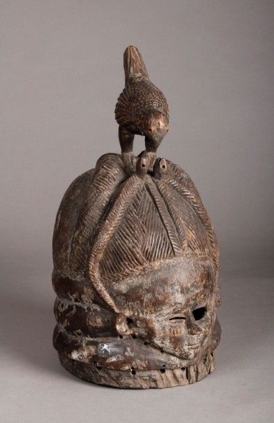 AFRIQUE Masque casque Pende en bois sombre finement incisé, surmonté d'un oiseau....