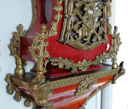 null Cartel violoné et sa console en bois repeint en rouge, ornés de bronzes à décor...