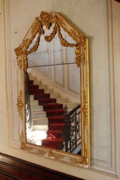 Grand miroir en bois et stuc doré sur fond...