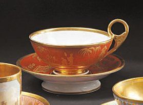 PARIS Tasse à thé et sa soucoupe à décor en or sur fond rouge à limitation du laque...