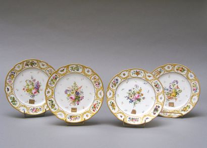 SEVRES Suite de quatre assiettes à bord contourné à décor polychrome de bouquets...