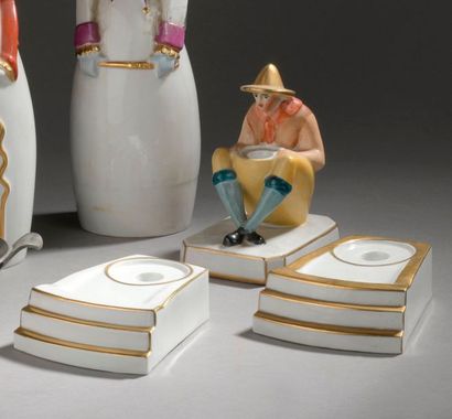 ROBJ ENCRIER en forme de personnage accroupi et deux socles en porcelaine émaillée...