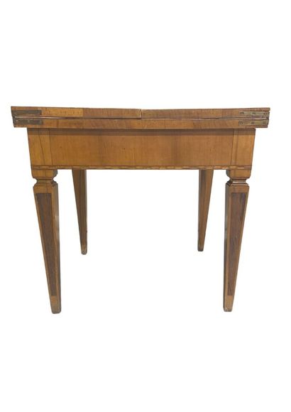 null Pedestal table in veneer, resting on sheath feet, the top opening by two flaps,...