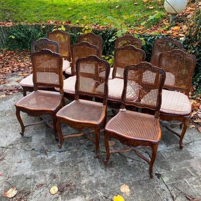  ELEVEN CHAIRS in moulded natural wood, carved with flowers, resting on arched legs...