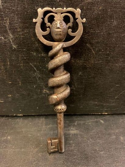 null Carved wrought iron key, the ring featuring a Janus head, the stem decorated...