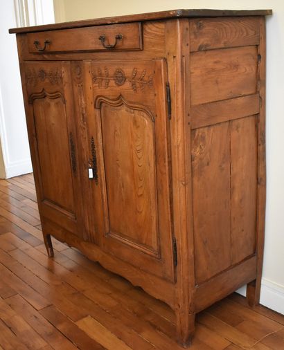 null Oak BUFFET carved with flowered branches, opening to a drawer and two doors....