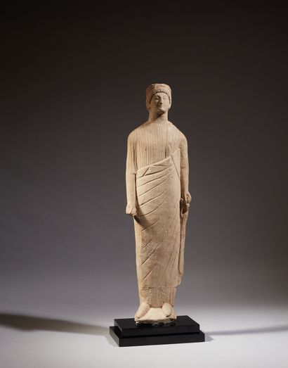 null 
Large statuette representing a standing orant dressed in a drapery, both arms...
