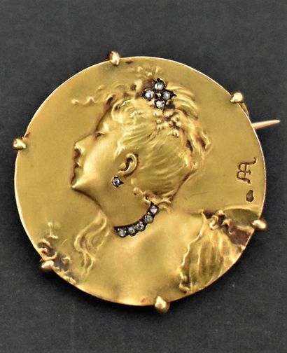 null Round gold brooch decorated with a woman's bust, set with small roses. Monogrammed...