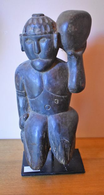 STATUTE of a kneeling character holding a...